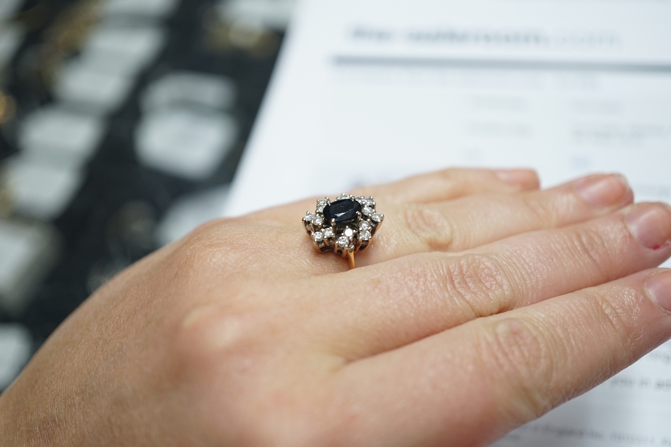 A modern 18ct gold, sapphire and diamond set oval cluster ring, size L, gross weight 4.8 grams.